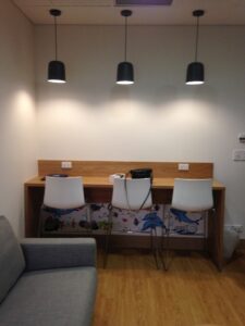 High bar and chairs with a phone and iPad charging station.